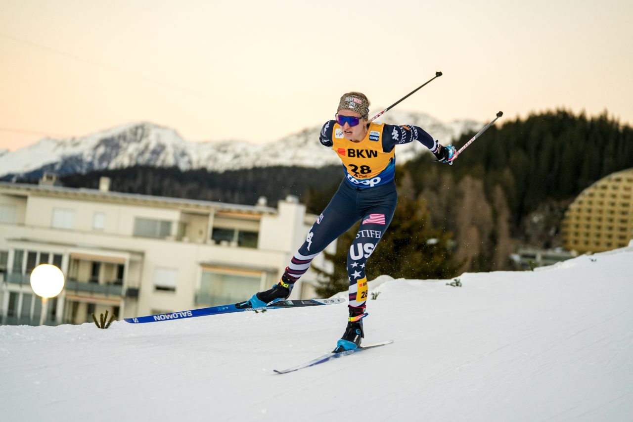 Alayna Sonnesyn in a U.S. race suit skating uphill with mountains behind her in Davos