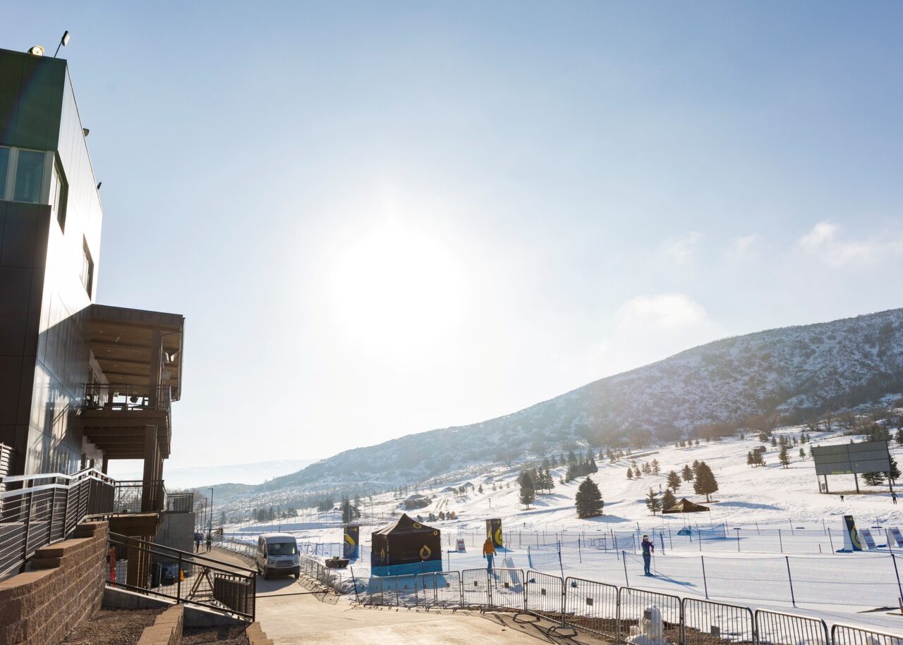 Race fencing, an inflatable arch and a skier in the start and finish area at Soldier Hollow on a sunny winter day